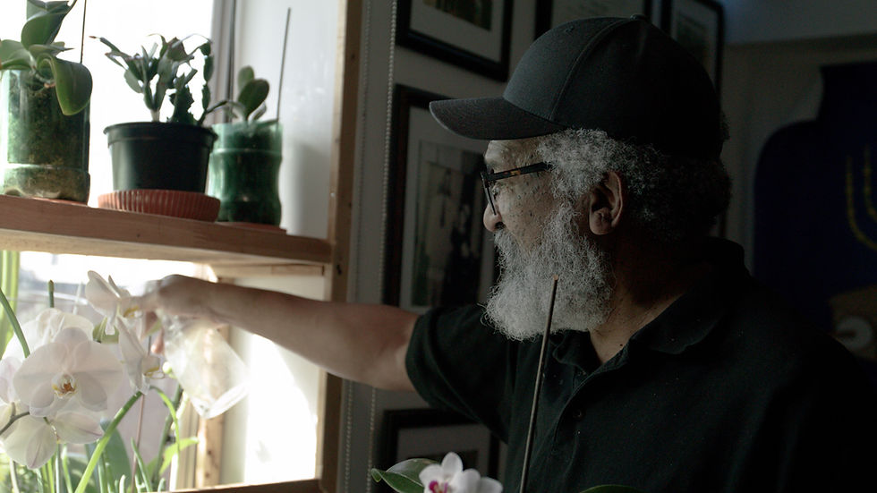 Denroy Davis, a St Hildas resident, watering his plants.  